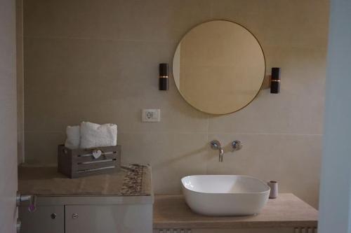 La salle de bains est pourvue d'un grand lavabo blanc et d'un miroir. dans l'établissement Apartman 1, à Omišalj