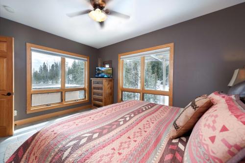 a bedroom with a bed with a ceiling fan and windows at 1601 Lake Purgatory Drive in Durango