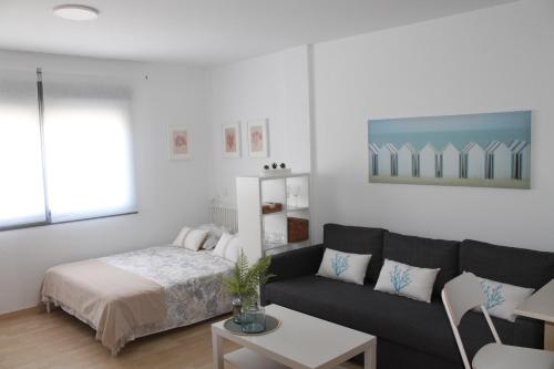 un soggiorno con divano e letto di Paseo Maritimo a Málaga