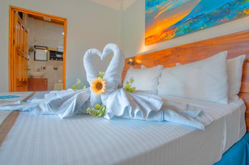 Una cama con dos cisnes vestidos de blanco en La Fortuna Downtown Hotel Boutique, en Fortuna