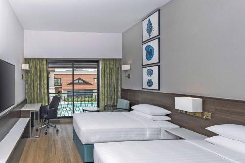 a hotel room with two beds and a television at Fairfield by Marriott Goa Benaulim in Benaulim