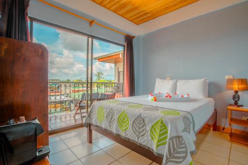 a bedroom with a bed and a large window at La Fortuna Downtown Hotel Boutique in Fortuna