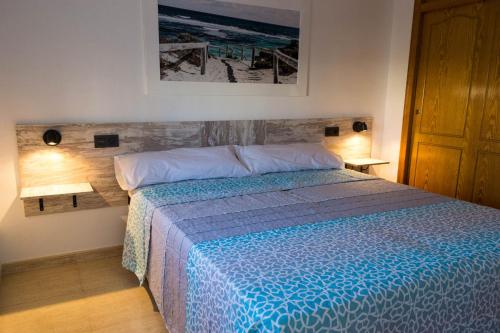 1 dormitorio con 1 cama con edredón azul en Villa del Sol, en Gran Alacant