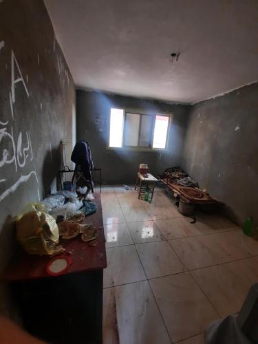 ein leeres Zimmer mit einem Tisch und einer Wand mit Graffiti in der Unterkunft المرج الشرقيه ش احمد ابو طالب in Kairo