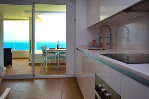 a kitchen with a sink and a table with a view of the ocean at THE SEA VIEW CALACEITE in Torrox Costa