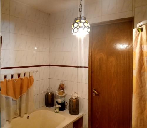 een badkamer met een bad, een wastafel en een licht bij Los siete Chakras in Ciudad Lujan de Cuyo