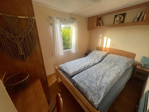 a small bedroom with a bed and a window at Mandala Mielno Camping in Mielno