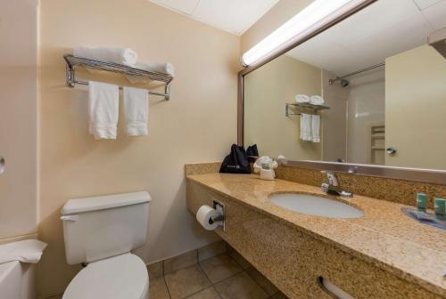 西黑文的住宿－新天堂西天堂貝斯特韋斯特行政酒店，一间带水槽、卫生间和镜子的浴室