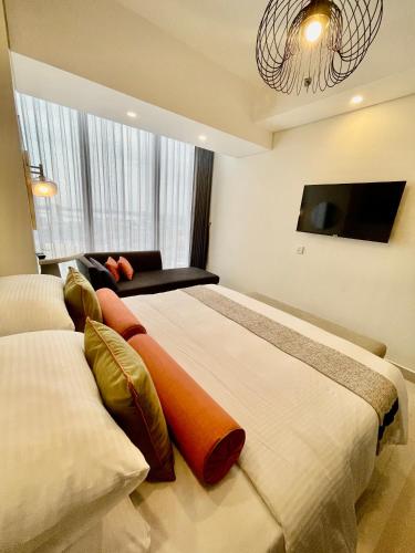 a bedroom with two beds and a flat screen tv at Verdela Pollux Meisterstadt Batam apartement in Batam Center