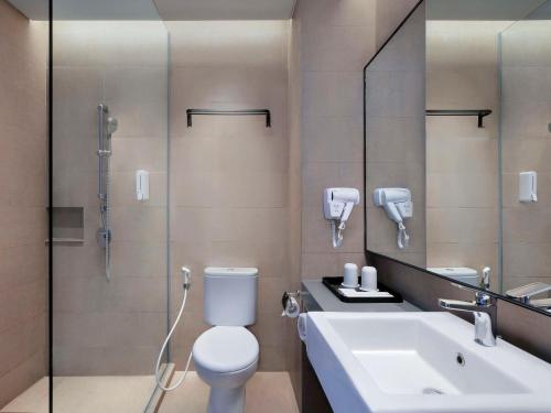 y baño con aseo, lavabo y ducha. en ibis Surabaya Tidar en Surabaya