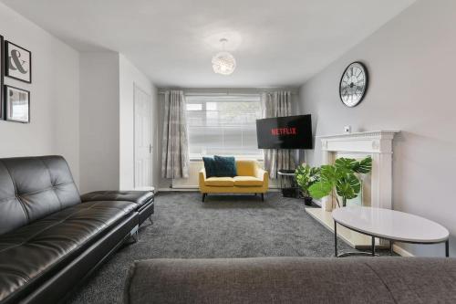 a living room with a couch and a yellow chair at Superb 3 bed house, homely comforts close to supermarkets, with private parking on gated premise in Sheffield