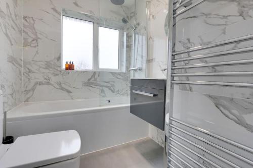 a bathroom with a tub and a toilet and a sink at Superb 3 bed house, with homely comforts and secure parking on gated premise in Sheffield
