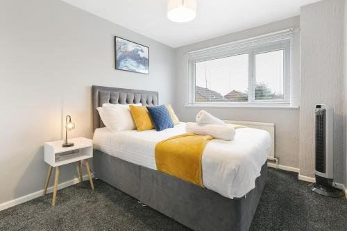 a bedroom with a large bed and a window at Superb 3 bed house, homely comforts close to supermarkets, with private parking on gated premise in Sheffield