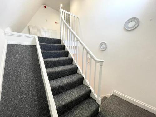 a staircase in a house with black carpet at Comfortable City Centre Room in Bristol