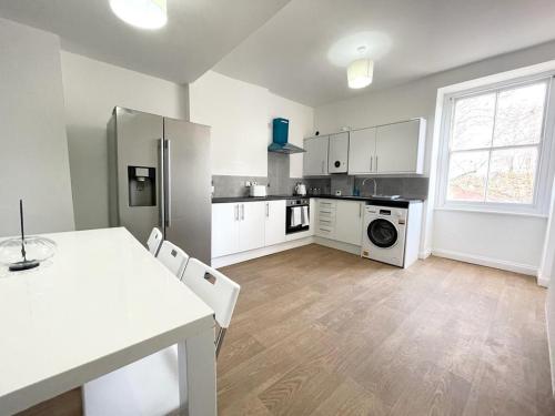 a kitchen with white appliances and a table and chairs at Comfortable City Centre Room in Bristol