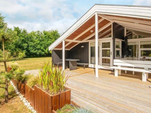 a house with a wooden deck with a bench on it at 4 person holiday home in Oksbøl-By Traum in Oksbøl