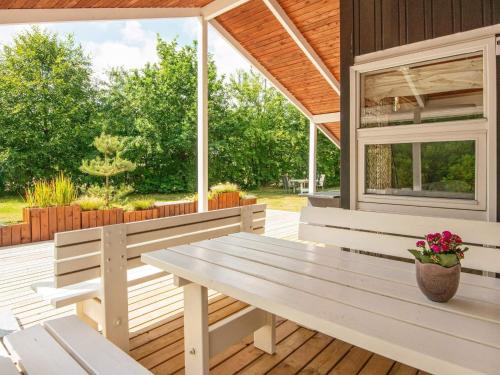 a porch with a bench and a window at 4 person holiday home in Oksbøl-By Traum in Oksbøl