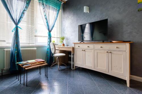 een kamer met een bureau en een televisie op een kast bij Severo Cento in Trieste