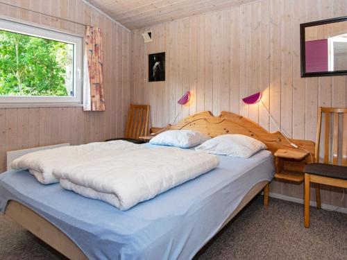 Nørre Nebelにある6 person holiday home in Nørre Nebel-By Traumのベッドと机と窓のある寝室