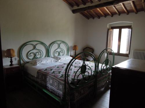 a bedroom with a bed with a wrought iron headboard at La Turra - Casa di Campagna in Greve in Chianti