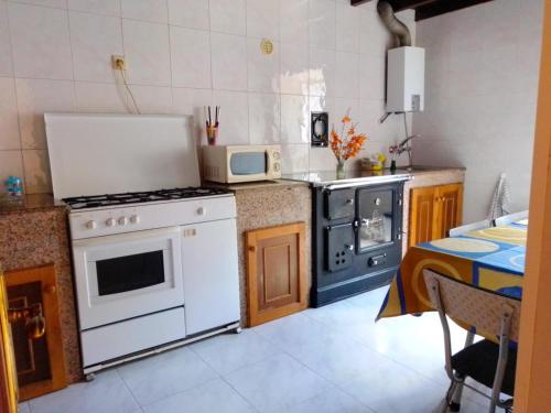 a kitchen with a white stove top oven next to a table at Casa Pepa de Enrique in Lira