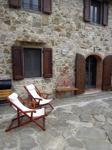a group of chairs and a bench in front of a building at La Turra - Casa di Campagna in Greve in Chianti