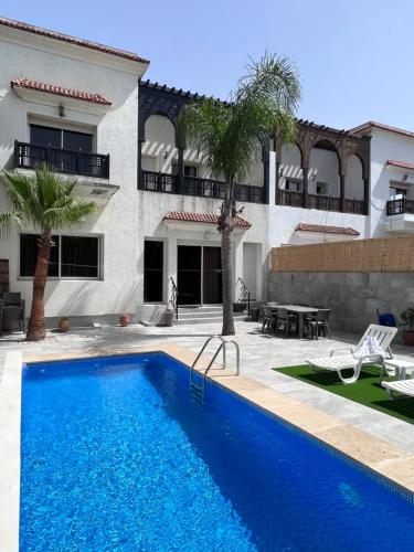une piscine en face d'un bâtiment dans l'établissement Les jardins Malabata, à Tanger