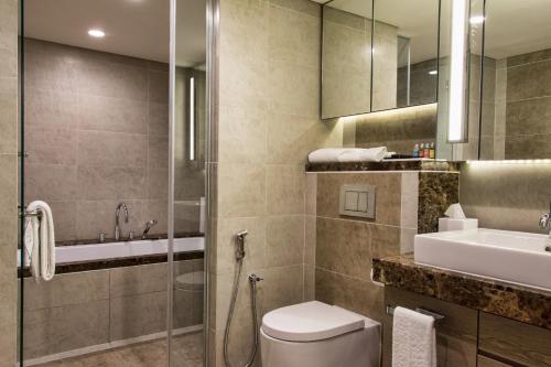a bathroom with a toilet and a sink and a shower at Ascott Sentral Kuala Lumpur in Kuala Lumpur