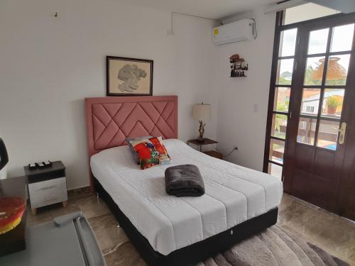 a bedroom with a bed with a pink head board at HOTEL EMPRESARIAL Arcoiris de mi llano in Paz de Ariporo