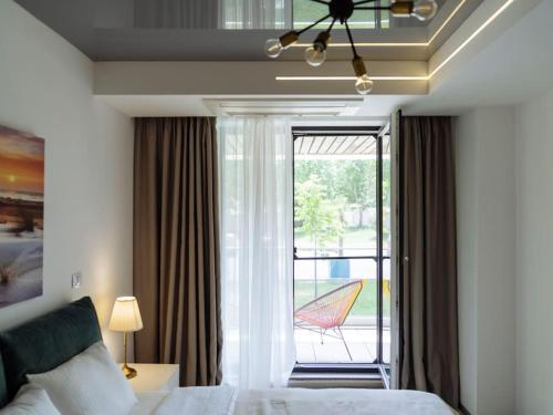 1 dormitorio con 1 cama y ventana con patio en Bond Apartment - Astria Olimp, en Olimp