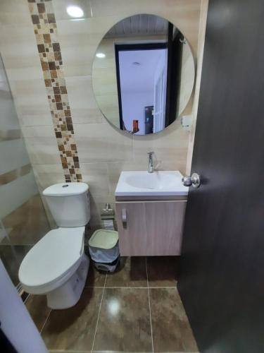 a bathroom with a toilet and a sink and a mirror at CASA VACACIONAL Babilonia in Girardot