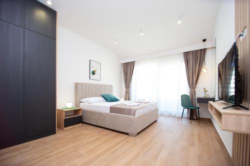 a bedroom with a bed and a television in it at Apartments Sirena in Budva