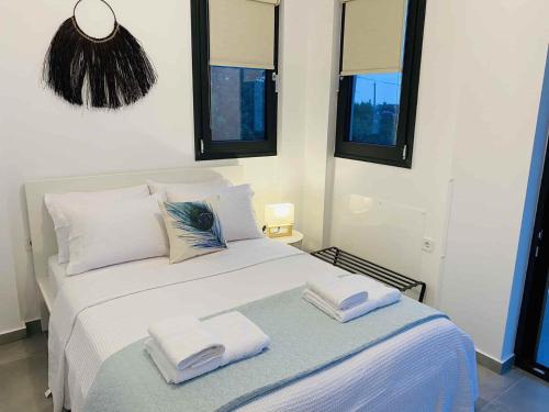 ein Schlafzimmer mit einem weißen Bett mit zwei Handtüchern darauf in der Unterkunft Casa al Mare in Nea Roda
