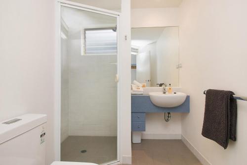 Short Stroll to White Sandy Beach في ساحة كاسوارينا: حمام أبيض مع حوض ومرآة