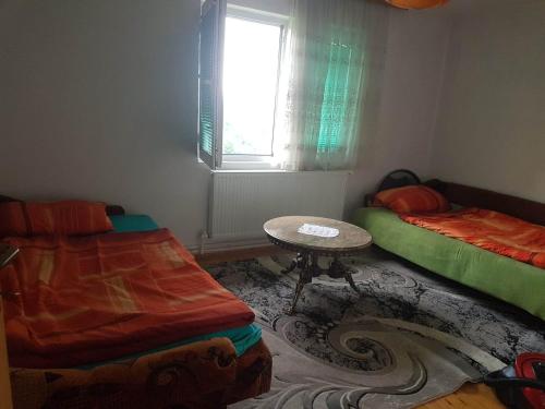 a room with two beds and a table and a window at Subaša in Visoko