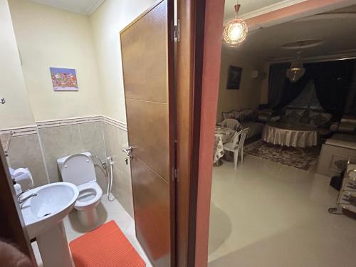 a bathroom with a toilet and a sink and a room at أشقار طنجة in Jbila