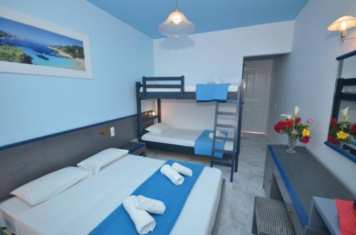 a bedroom with two beds and a bunk bed at Hotel Elena Ermones in Ermones
