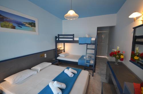 a bedroom with two beds and a bunk bed at Hotel Elena Ermones in Ermones