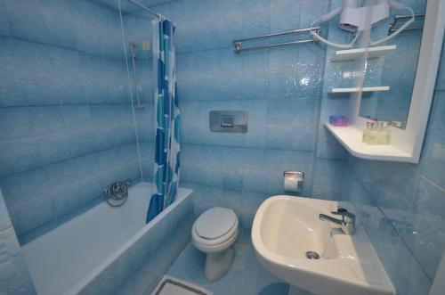 a bathroom with a toilet and a sink and a shower at Hotel Elena Ermones in Ermones