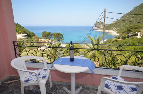 a table and chairs on a balcony with a view of the ocean at Hotel Elena Ermones in Ermones