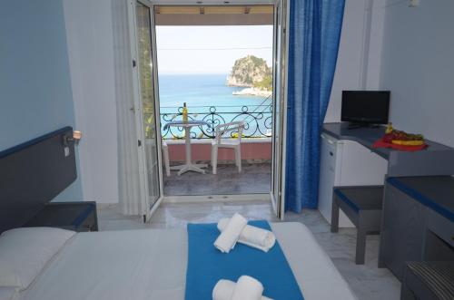 a bedroom with a bed and a view of the ocean at Hotel Elena Ermones in Ermones