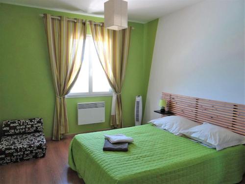 Un dormitorio verde con una cama grande y una ventana en Marguerite, en Callian