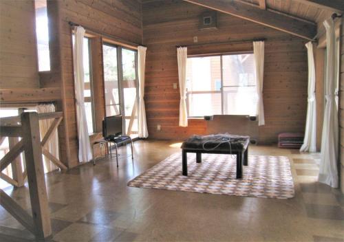 un soggiorno con tavolo in una camera con finestre di Gozenyama Youth Travel Village - Vacation STAY 46761v 