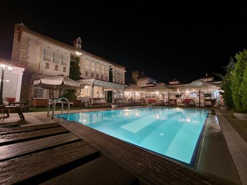 a large swimming pool in a hotel at night at Kerme Ottoman Alacati in Alaçatı