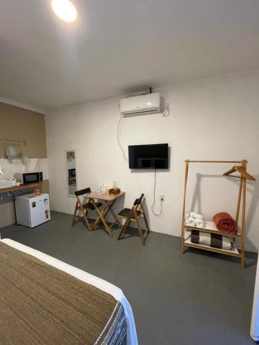 1 dormitorio con 1 cama, escritorio y TV en Pousada Alto da Serra en Serra de São Bento