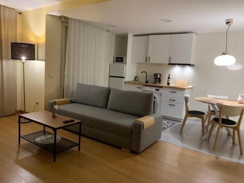 sala de estar con sofá, mesa y cocina en Casa Cristina - Rioja II en Cenicero