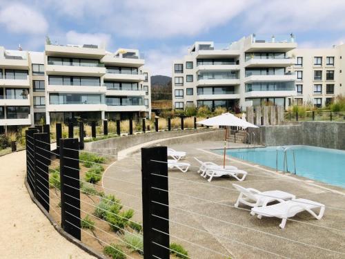 a resort with a swimming pool and some buildings at Departamento Banus Marbella piso 1 in Maitencillo