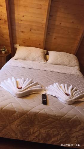a bed with white sheets and pillows on it at Cabañas Alpina in San Agustín