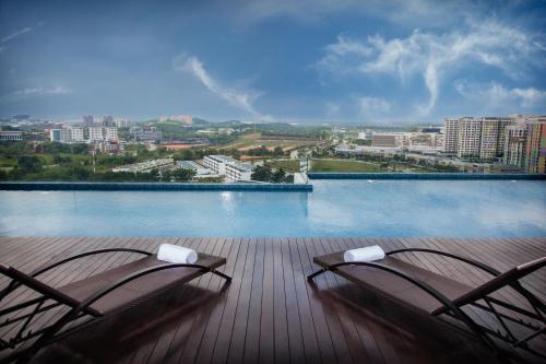 two chairs on a deck with a view of the water at Citadines DPulze Cyberjaya in Cyberjaya