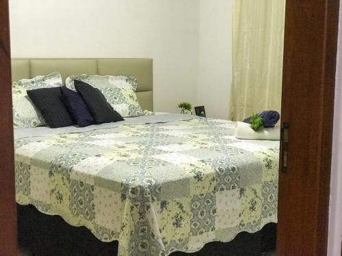 a bedroom with a bed with a white and blue blanket at Casa Cantinho Do Sossego Piri in Pirenópolis